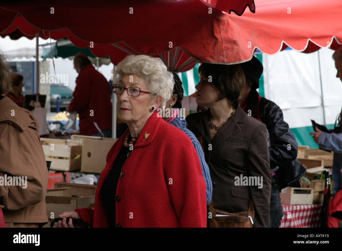 Senior französische Dame Warteschlangen an orientalischen Garküche Concarneau Markt Stockfoto