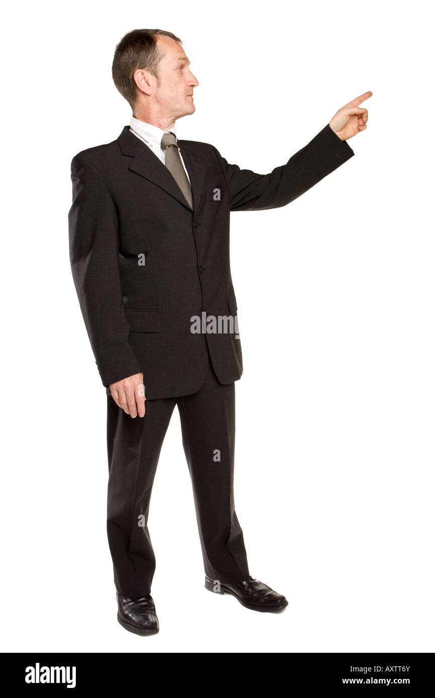 Geschäftsmann steht in einem schwarzen Anzug, der mit dem Finger die richtige Richtung zeigt. Hintergrund ist reines Weiß. Stockfoto