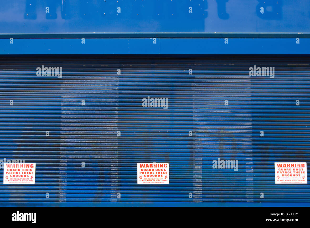 blauen Fensterläden Fassade von einem stillgelegten Industrieareal mit Warnzeichen der Garde Hunde patrouillierenden Räumlichkeiten Stockfoto