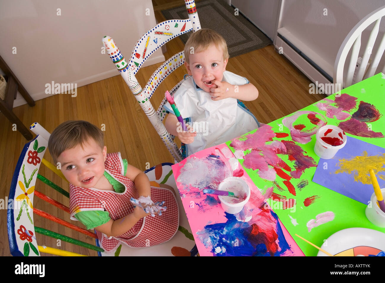 Zwei zwei - jährigen Mädchen malen mit Farben Poster am Küchentisch & Spaß Alaska USA Stockfoto