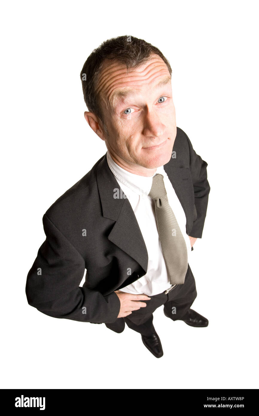 Geschäftsmann, der in einem schwarzen Anzug mit einem überraschenden Gesicht steht. Die Aussicht ist von oben nach unten. Stockfoto