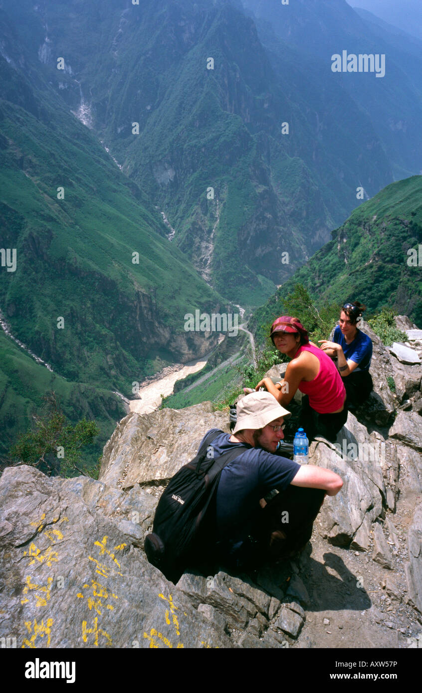 Reisende, die eine Pause beim Wandern hoch über dem Fluss Jangtse bei Tigersprung-Schlucht in der Provinz Yunnan. Stockfoto