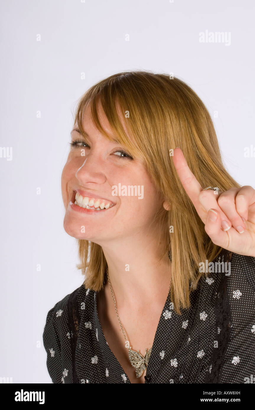 Erster Platz: eine lächelnde junge Frau mit ersten Finger angehoben feiert den Sieg. Bild von Jim Holden. Stockfoto