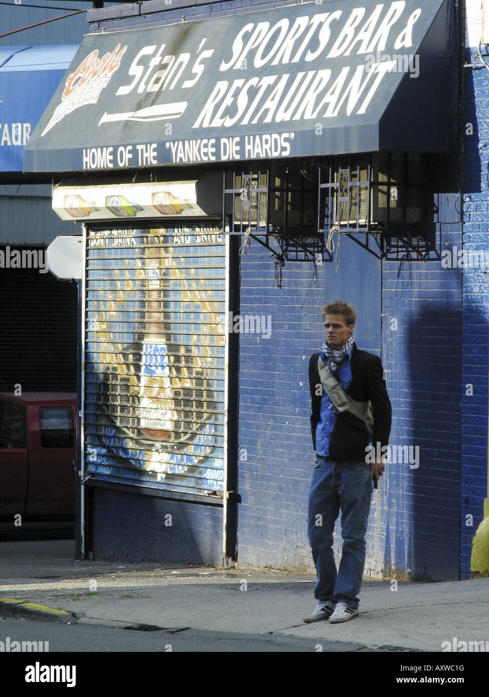 blonder Jüngling steht neben einem Pub des Yankee-sterben-Hards, USA, Bronx, New York Stockfoto
