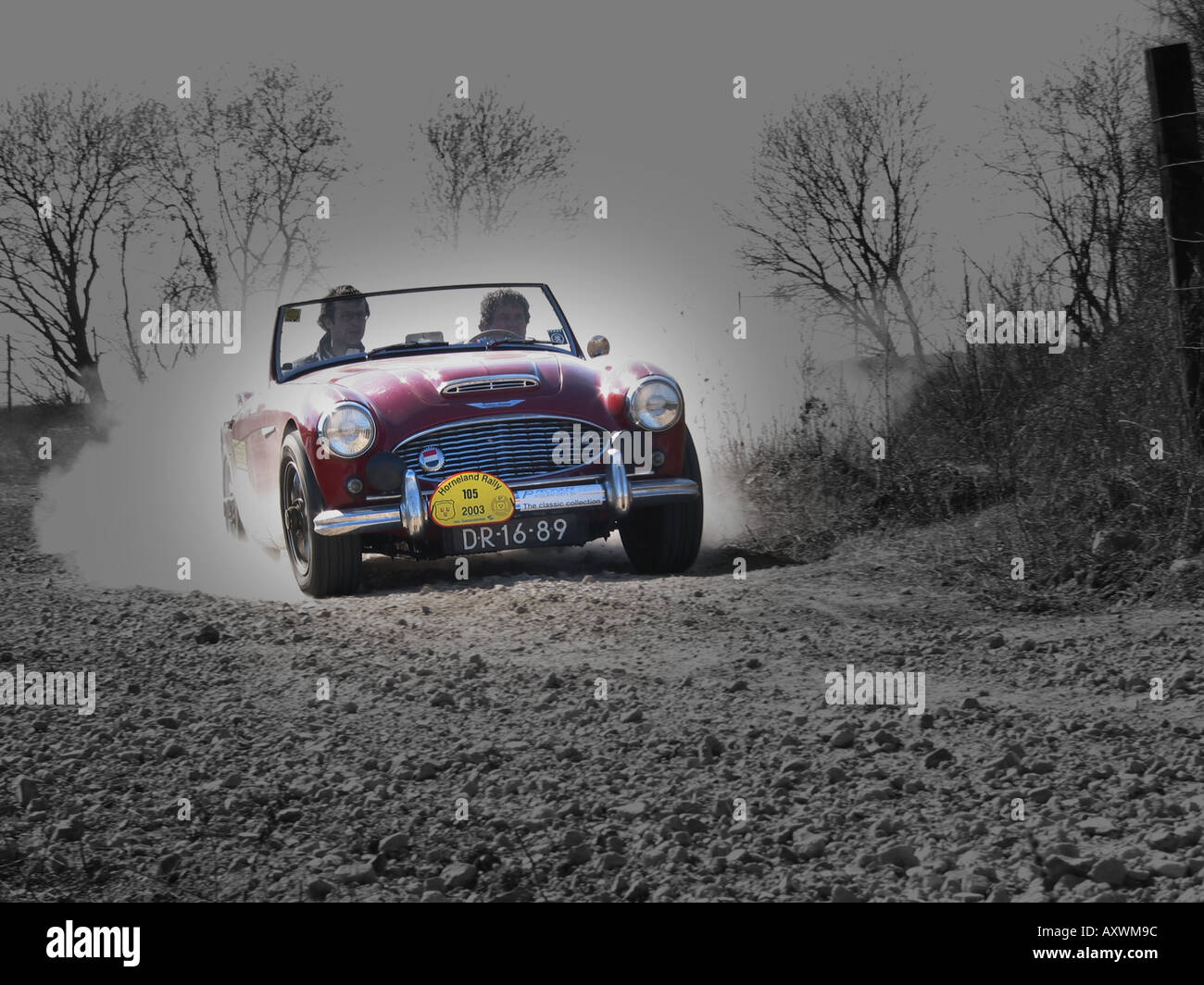 roten Rallye Austin Healey 100/6 Roadster mit Geschwindigkeit auf Schotterstraße am internationalen Horneland Rallye Niederlande Stockfoto