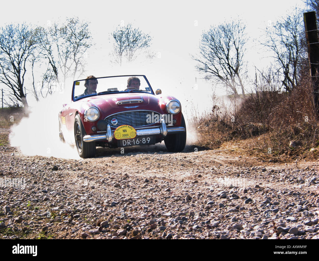 roten Rallye Austin Healey 100/6 Roadster mit Geschwindigkeit auf Schotterstraße am internationalen Horneland Rallye Niederlande Stockfoto