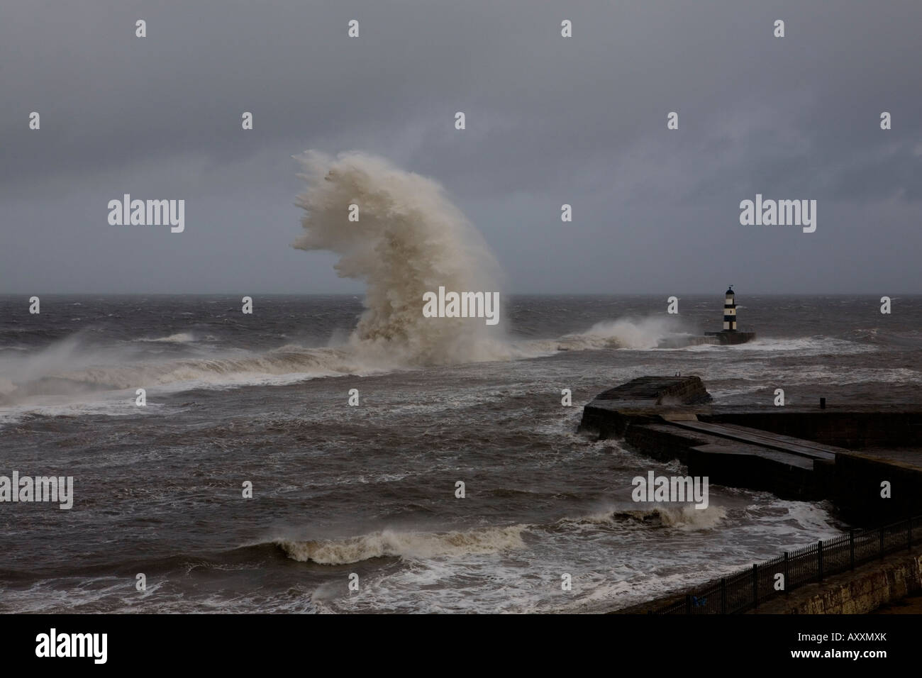 Sturmwellen brechen über die Ufermauer & Leuchtturm am Seaham Pier im Vereinigten Königreich Stockfoto