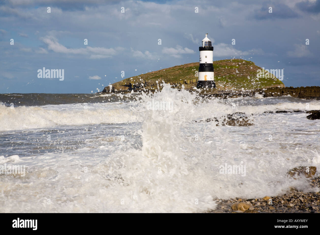 Raues Meer bei windigem Wetter im Leuchtturm Penmon mit großen Wellen, die auf Felsen an der wilden Küste abstürzen. Penmon Point Anglesey North Wales Großbritannien Stockfoto