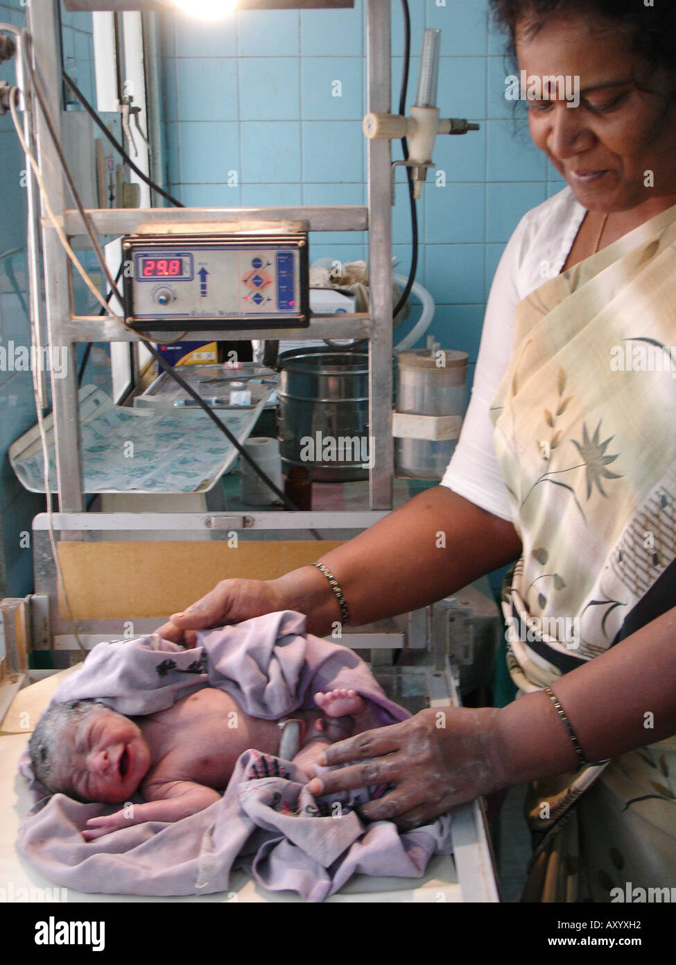 Ein paar Minuten altes neugeborenes Baby in den Händen der Hebamme in einem Krankenhaus im ländlichen Raum, Indien Stockfoto