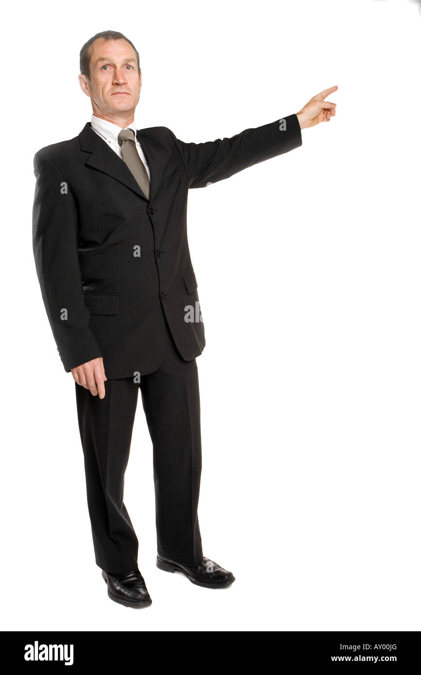 Geschäftsmann steht in einem schwarzen Anzug, der mit dem Finger die richtige Richtung zeigt. Hintergrund ist reines Weiß. Stockfoto