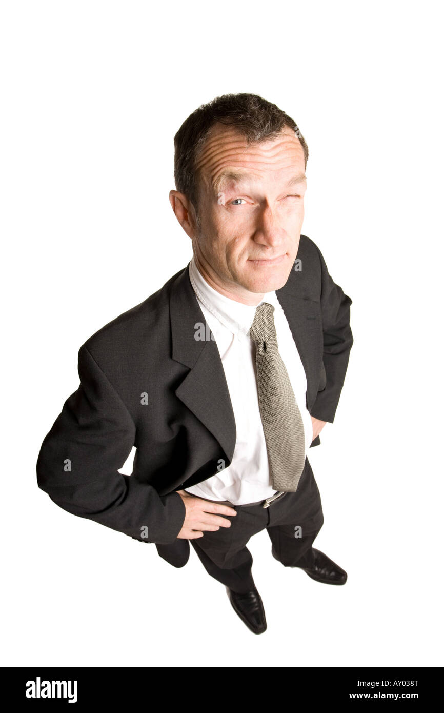 Business Mann in Anzug und Krawatte ist zu zweifeln, mit einem überraschenden Ausdruck. Er hat zwei Hände auf seine Hüften. Stockfoto