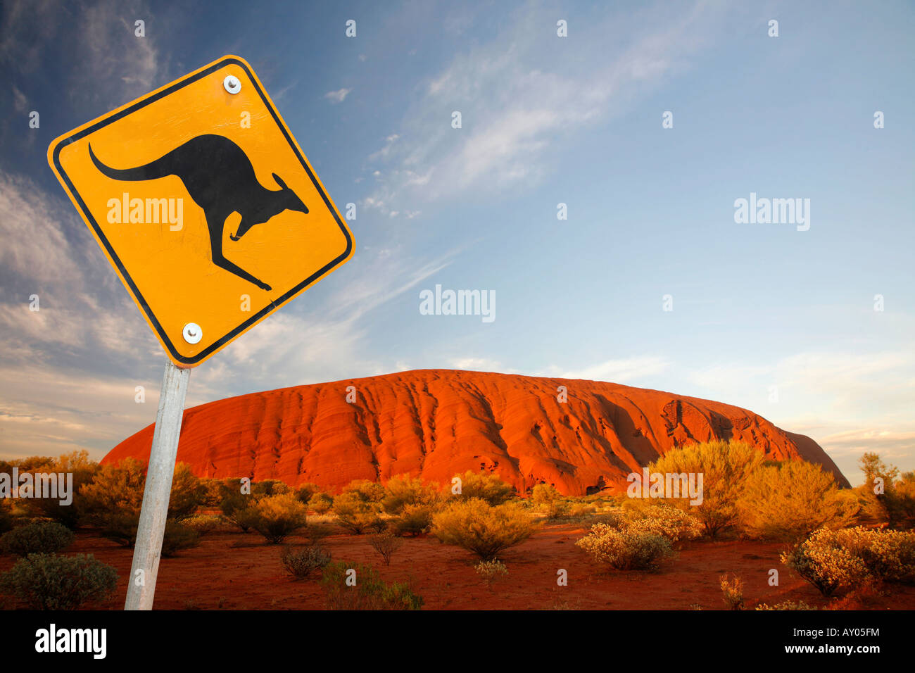 Uluru / Ayers Rock bei Sonnenuntergang mit ikonischen Känguru Schild Stockfoto