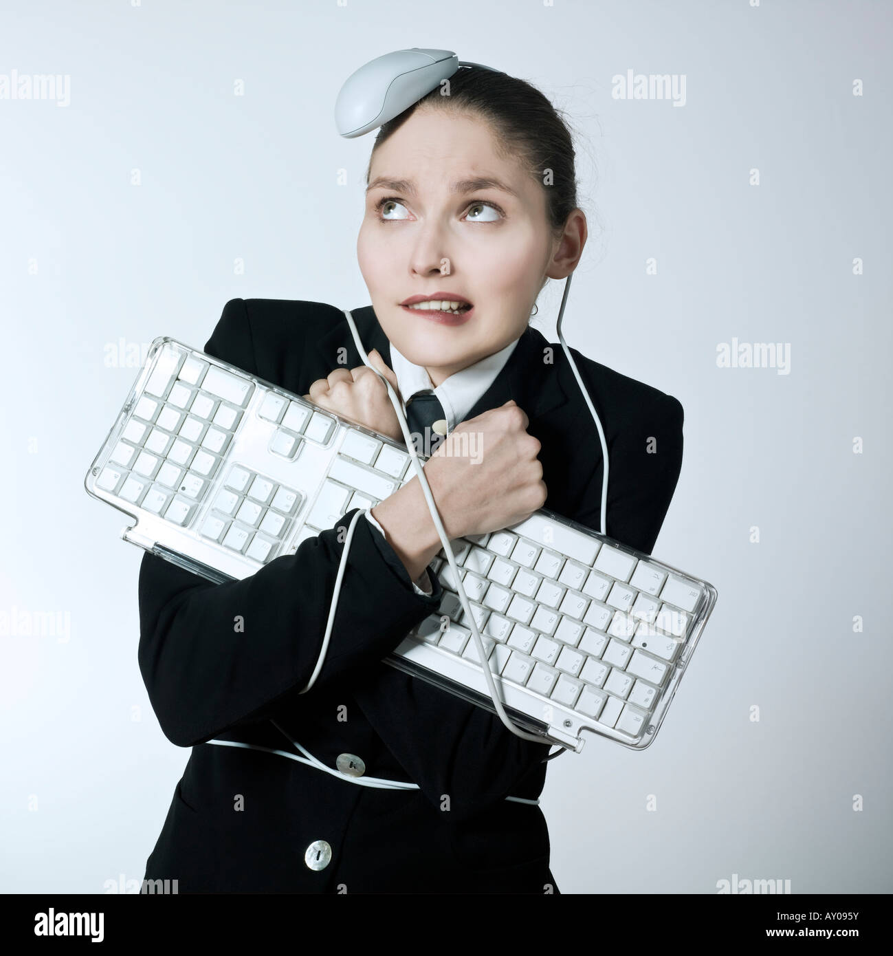 Studio gedreht Porträt einer schönen jungen Frau in einem Kostüm Anzug an eine Computer-Tastatur und wurde Angriff per Mausklick Stockfoto