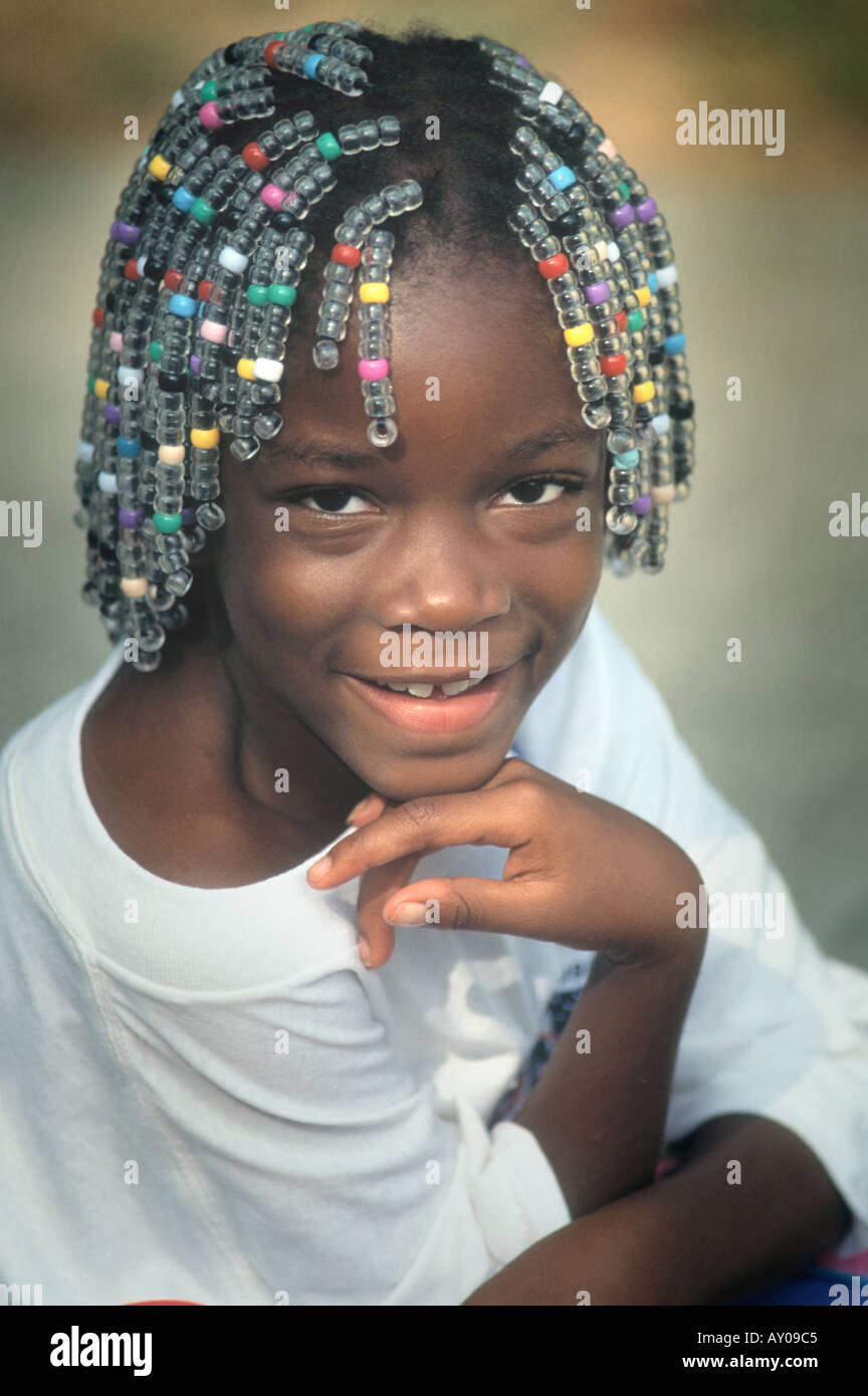 6 Jahre altes lächelndes schwarzes Mädchen mit Perlen in ihr Haare Stockfoto