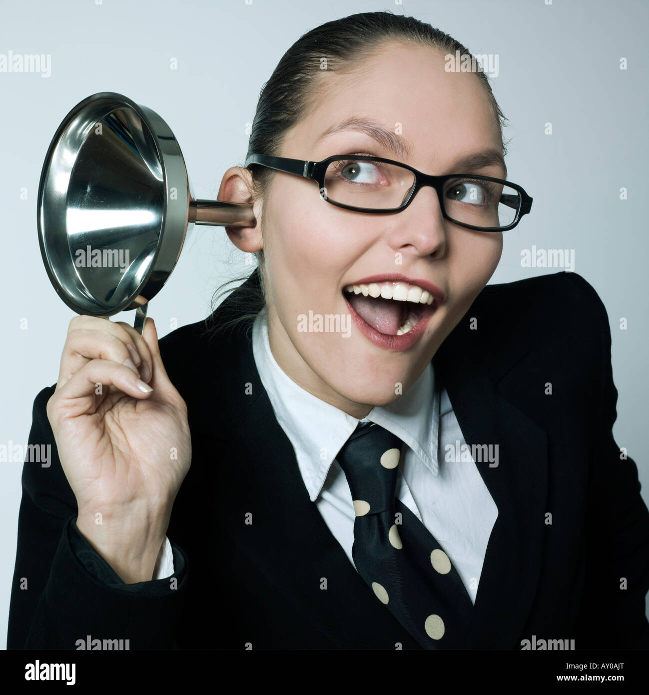Studioportrait erschossen eine schöne neugierig Business-Frau in ein Kostüm Anzug Hörgerät Trichter neugierig Spionage Klatsch Stockfoto