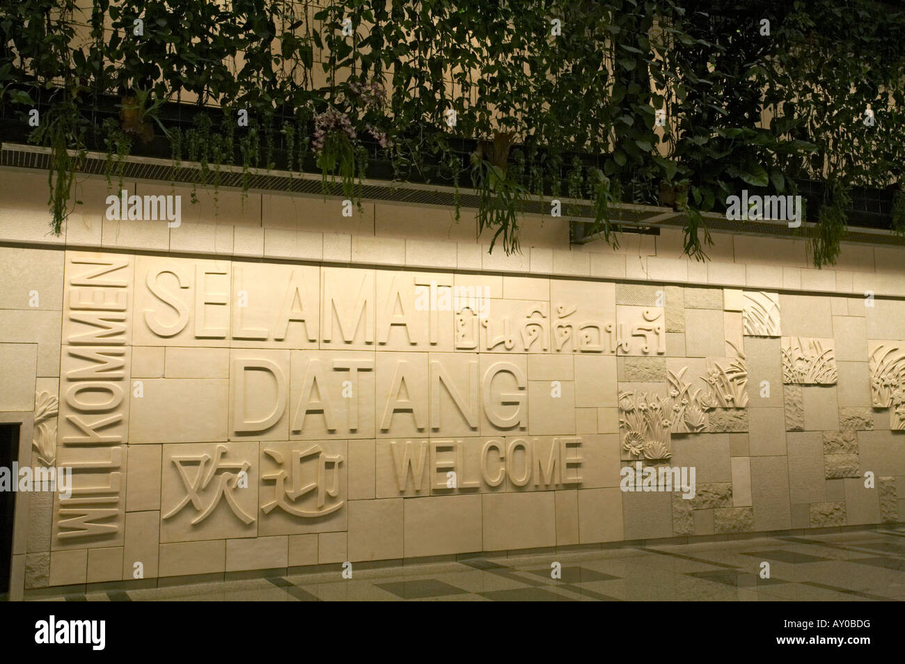 Skulpturen aus Sandstein Kunst Wand-Display, hinter der grünen Wand in der Ankunftshalle im Terminal 3, Flughafen Changi, Singapur Stockfoto