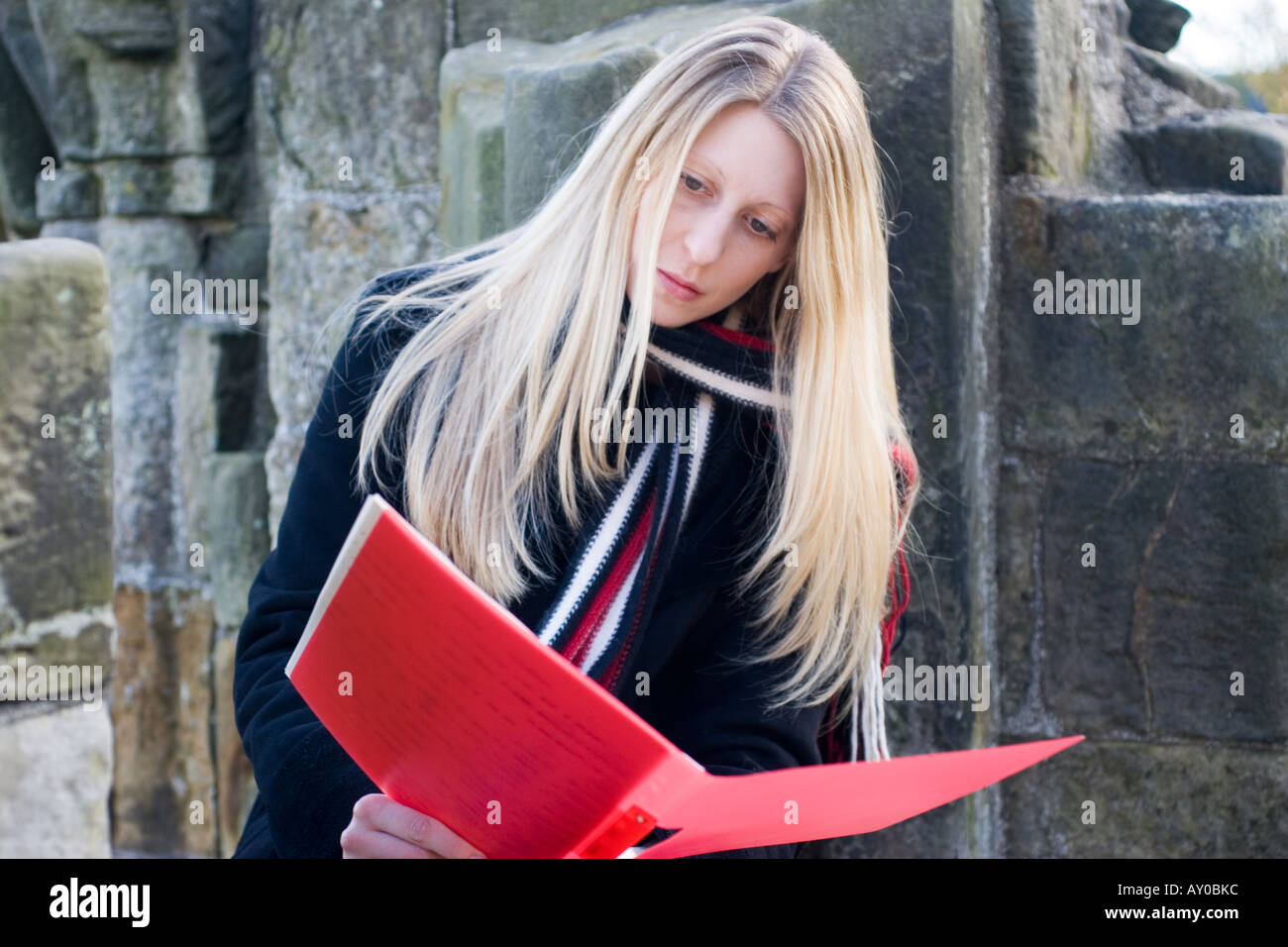 Schüler lesen Papierkram aus Ordner "rot" Stockfoto