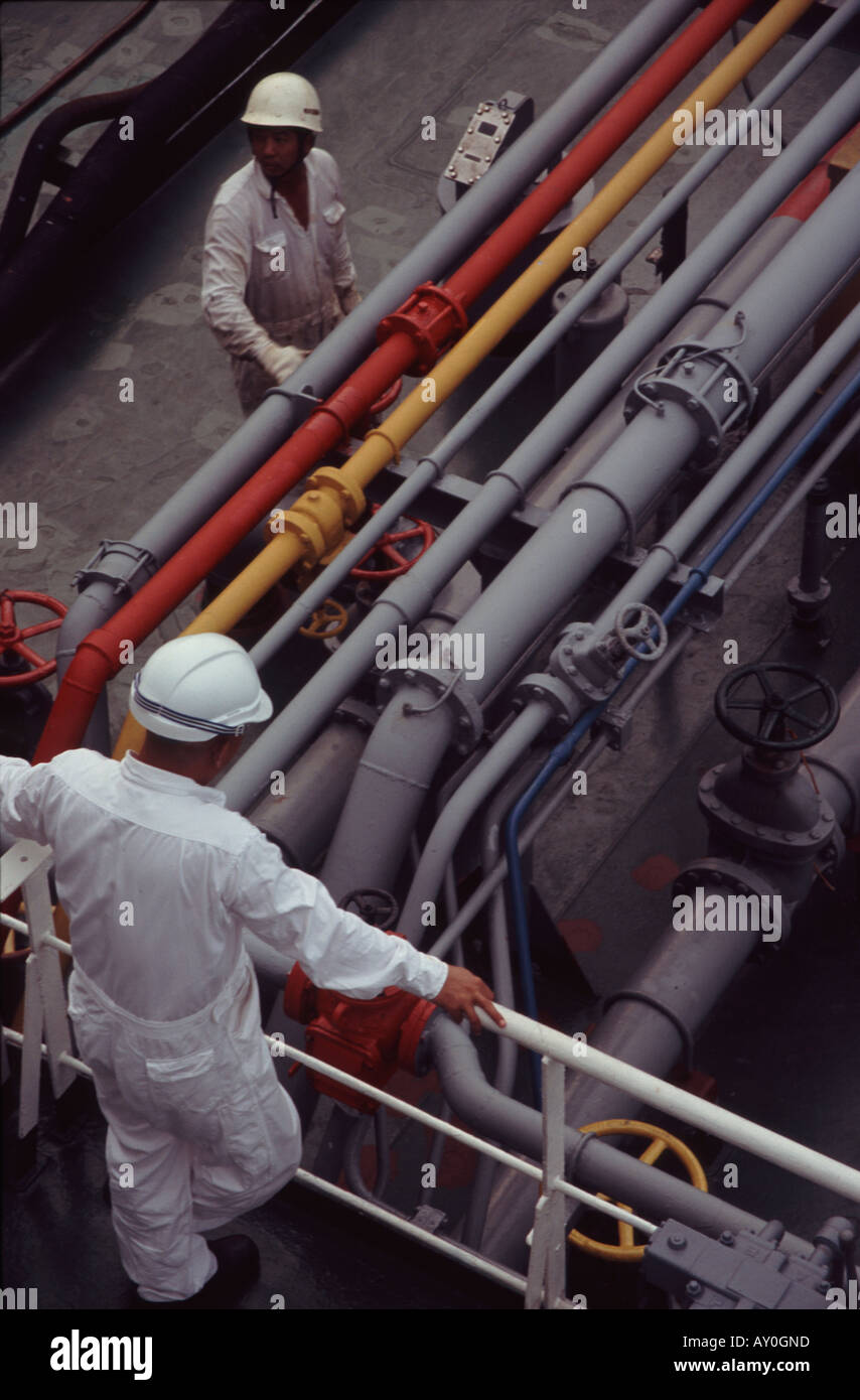 Bunker Schiff Arbeiter überprüfen Kraftstoffleitungen auf Bunker in Singapur Hafen Fernost Asien versenden Stockfoto