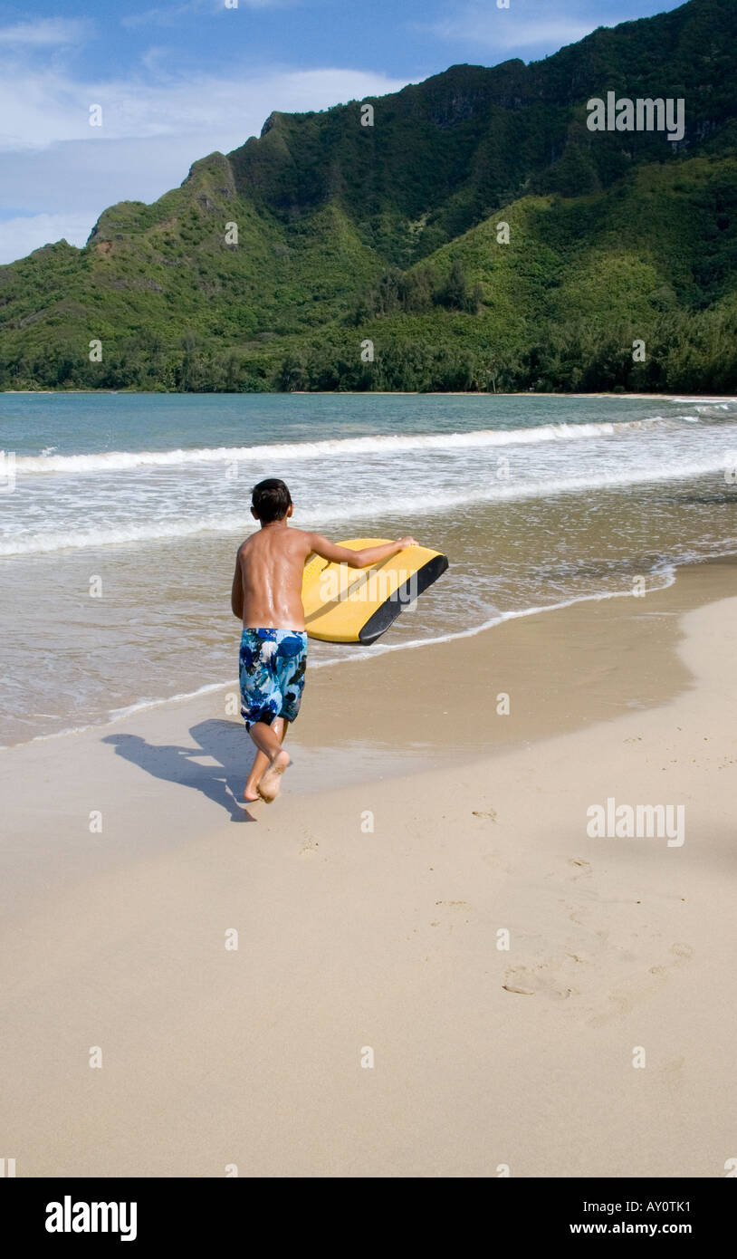 Junge zu überfliegen Board bei Kahana Bay, Hawaiii Stockfoto