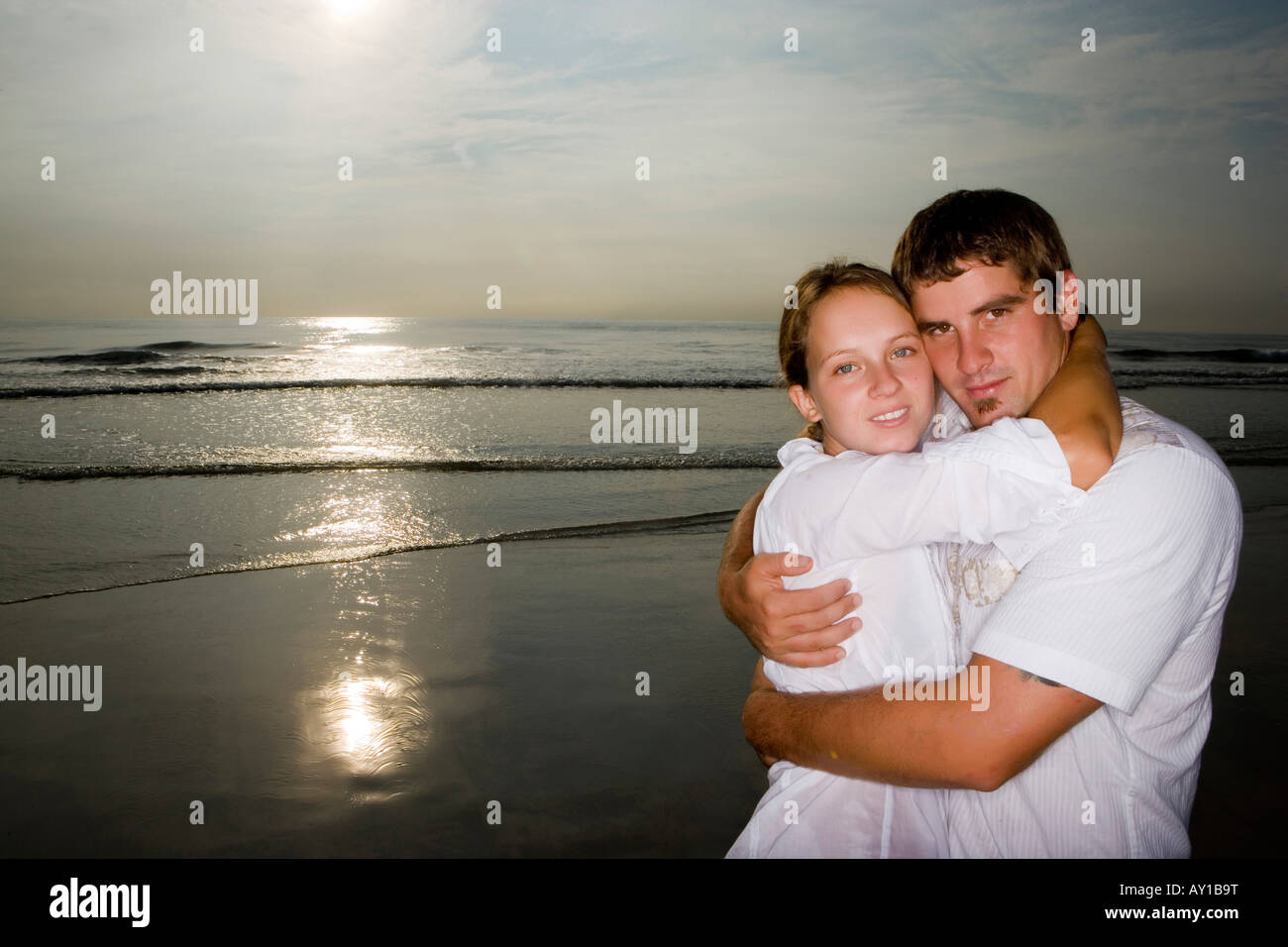 Porträt eines jungen Paares umarmen am Strand Stockfoto