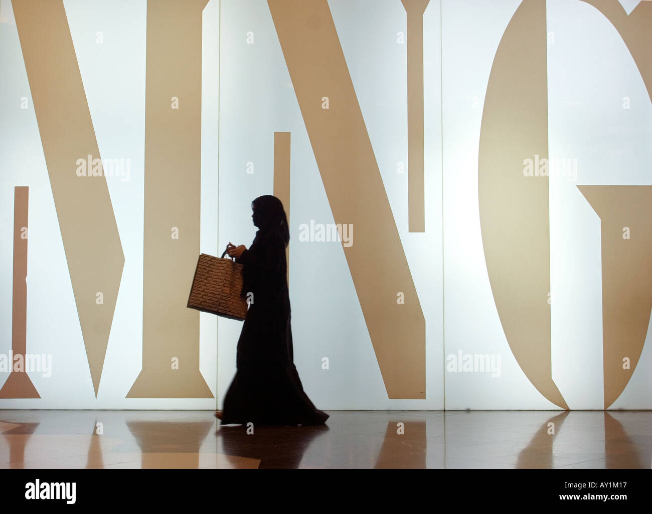 Die muslimische Frau zu Fuß durch einen Modeladen in Deira City Center Shopping-Mall, Dubai, Vereinigte Arabische Emirate Stockfoto
