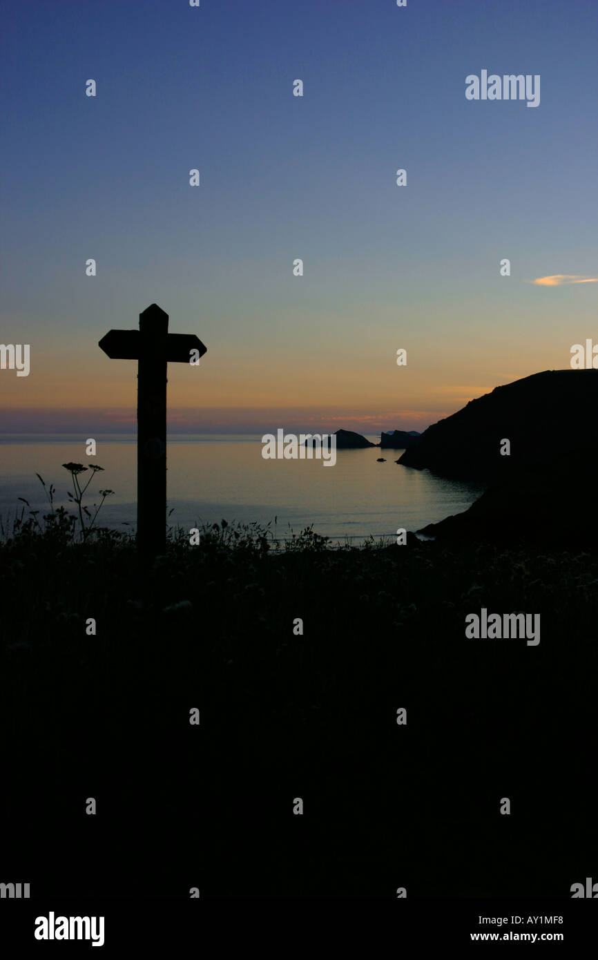 Wegweiser auf dem Felsenweg oberhalb Newgale Blick auf St David s Kopf und Ramsey Island bei Sonnenuntergang Stockfoto