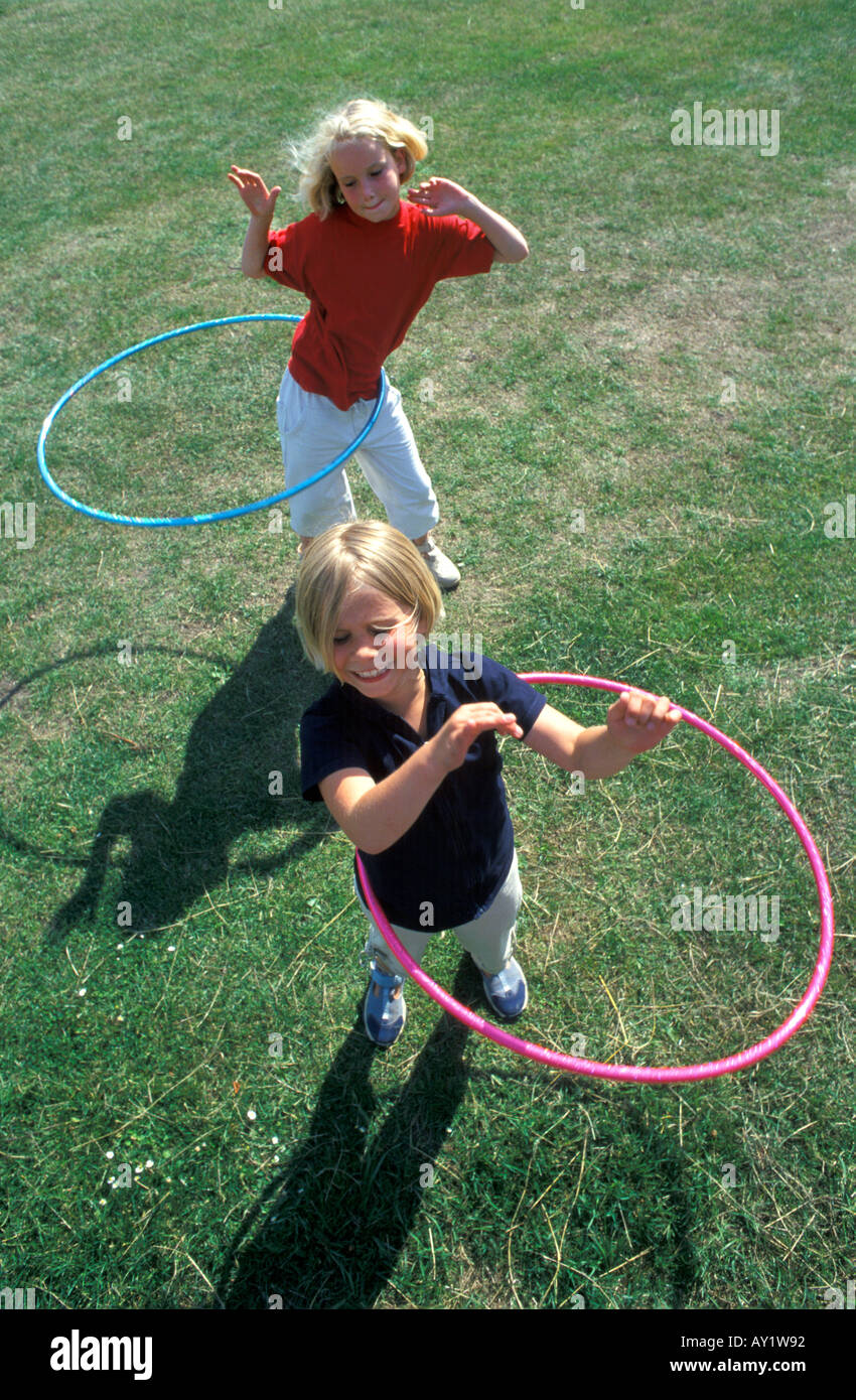 Zwei blonde Mädchen bewegt sich mit einem Hula Hoop Reifen Stockfoto