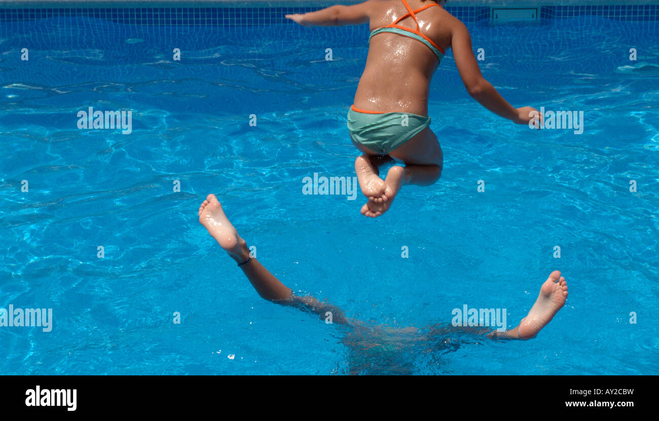 Kinder springen in einen pool Stockfoto