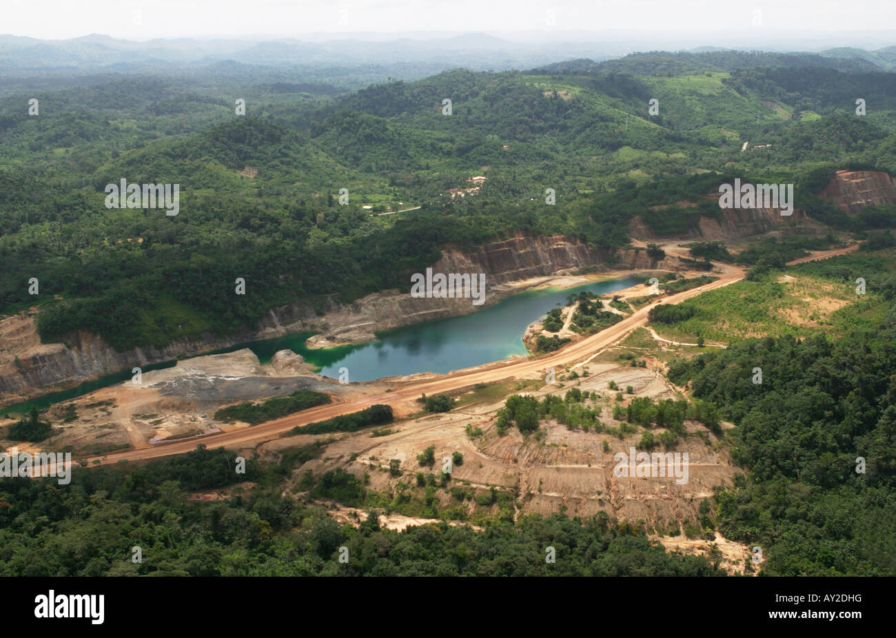 Luftaufnahme der Teil der Oberfläche Goldmine Konzession, mit teilweise rehabilitiert, umgepflanzt alten Abfall Grube im Vordergrund, Ghana Stockfoto