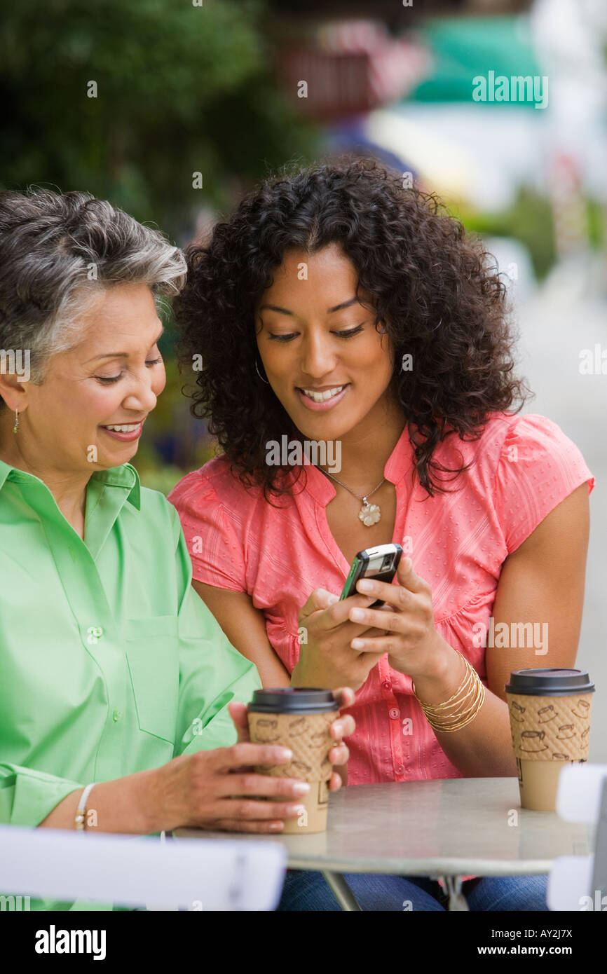 African American Mutter und Erwachsene Tochter Blick auf Handy Stockfoto