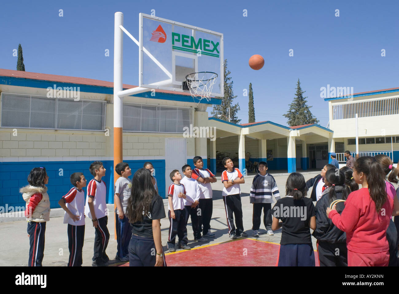 Schüler an der Grundschule Lazaro Cardenas in Camargo spielen Basketball mit Zielbretter, die PEMEX-Logo tragen Stockfoto