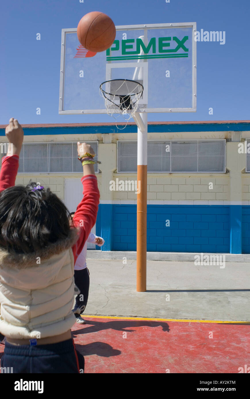 Schüler an der Grundschule Lazaro Cardenas in Camargo spielen Basketball mit Zielbretter, die PEMEX-Logo tragen Stockfoto