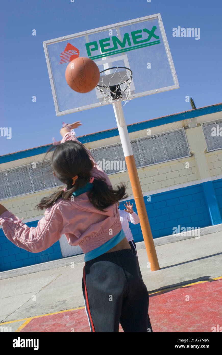 Schüler an der Grundschule Lazaro Cardenas in Camargo spielen Basketball mit Zielbretter, die PEMEX-Logo tragen Stockfoto