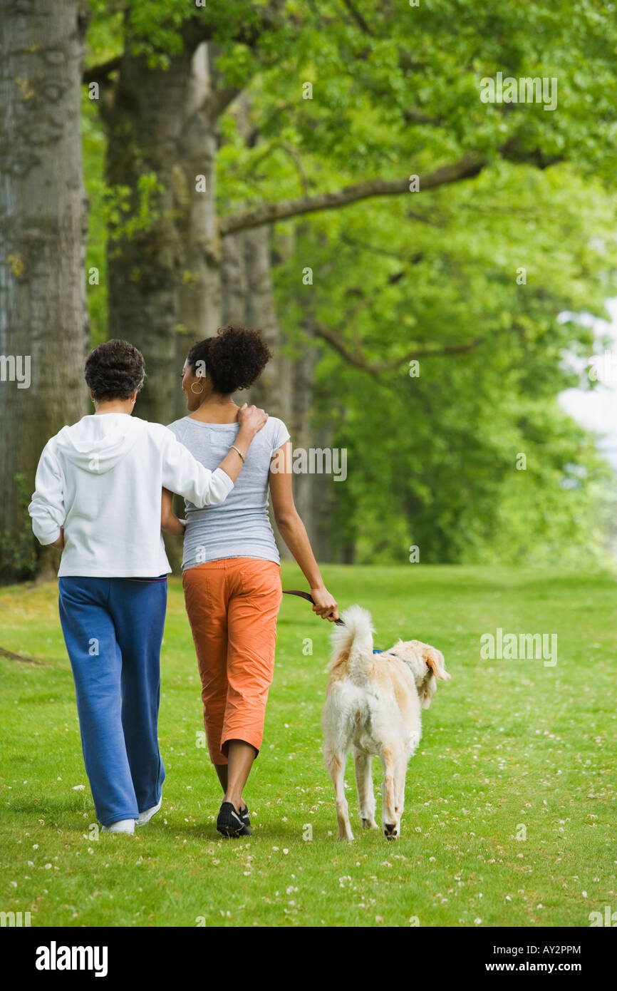 African American Mutter und Erwachsene Tochter walking Hund Stockfoto