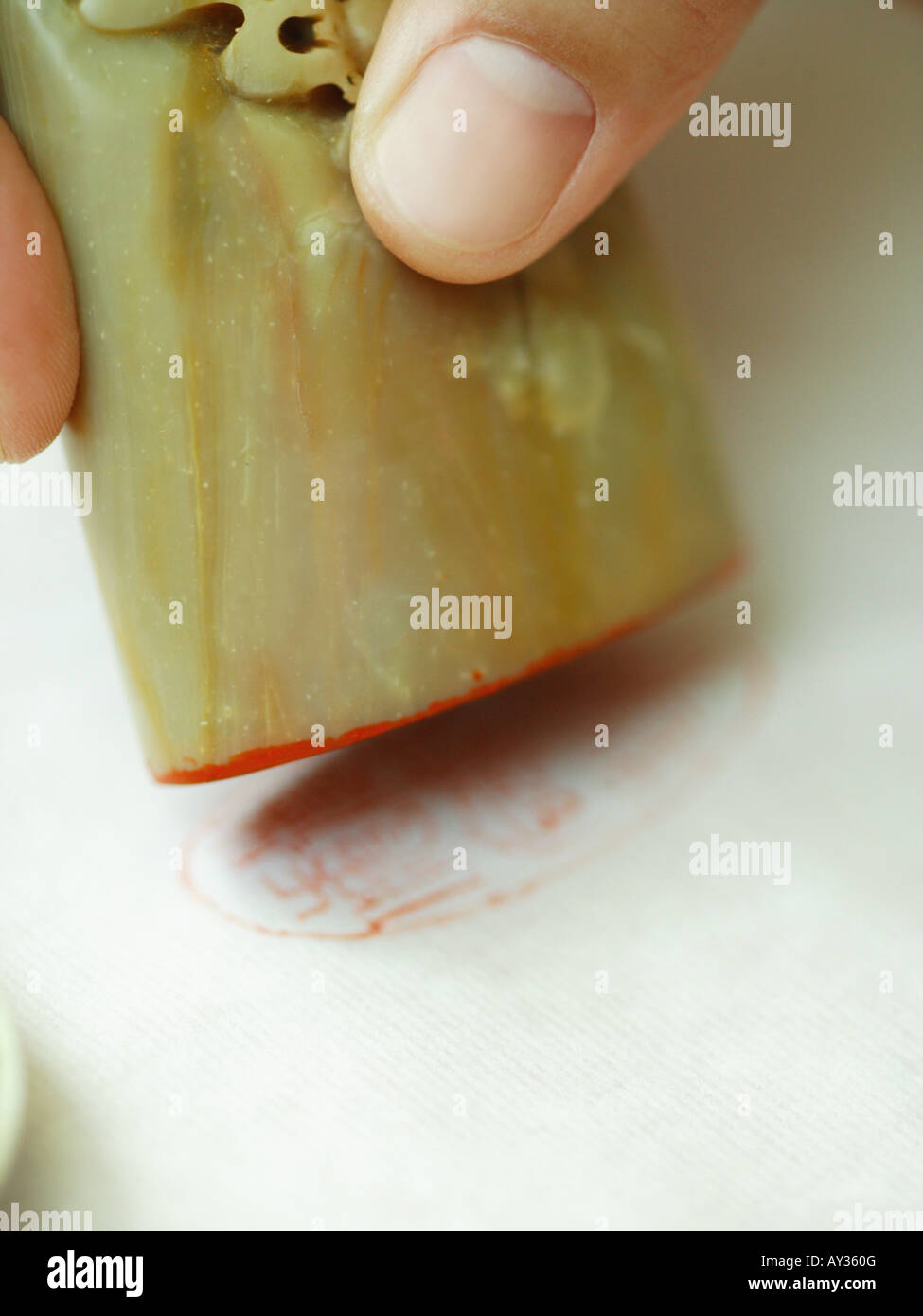 Nahaufnahme der Hand einer Person, die mit einem Stempel Stockfoto
