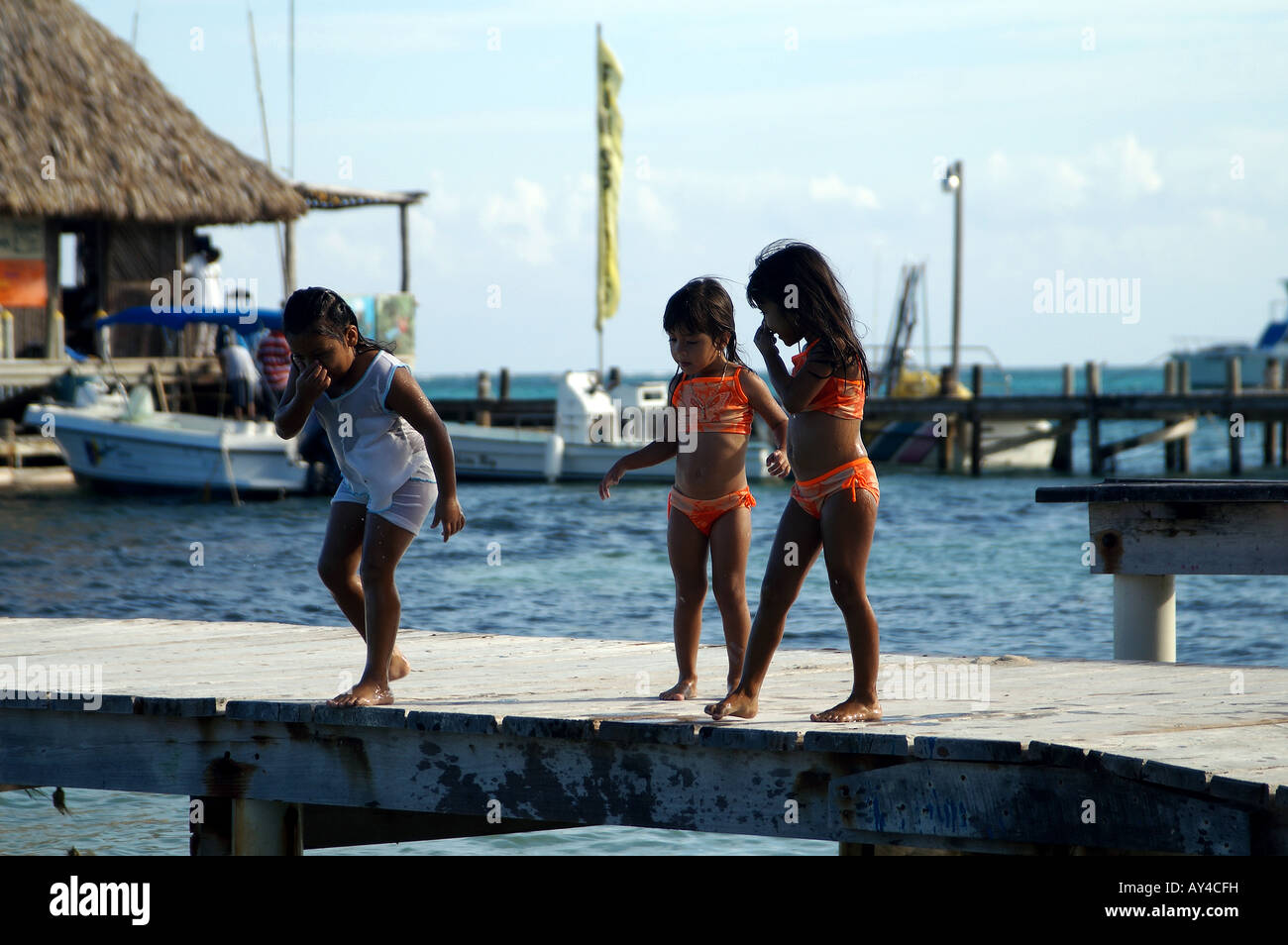 Kinder spielen auf einem Dock am Ambergris Caye, Belize Stockfoto