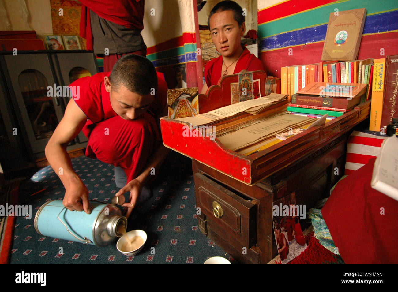Buddhistische Mönche im Kloster Sera in Lhasa dienen Yak Buttertee Besucher. Stockfoto