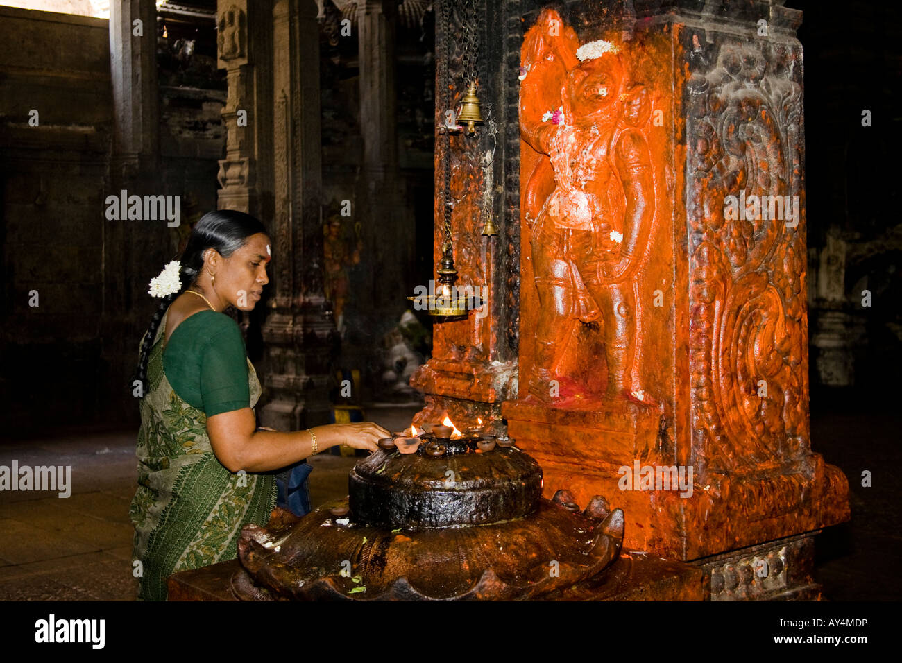 Weibliche Verehrer Anzünden einer Kerze neben einem Schrein, Meenakshi Tempel, Madurai, Tamil Nadu, Indien Stockfoto