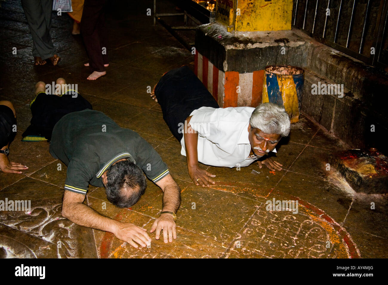 Männer auf Boden liegend, beten neben Schrein innen Meenakshi Tempel, Madurai, Tamil Nadu, Indien Stockfoto