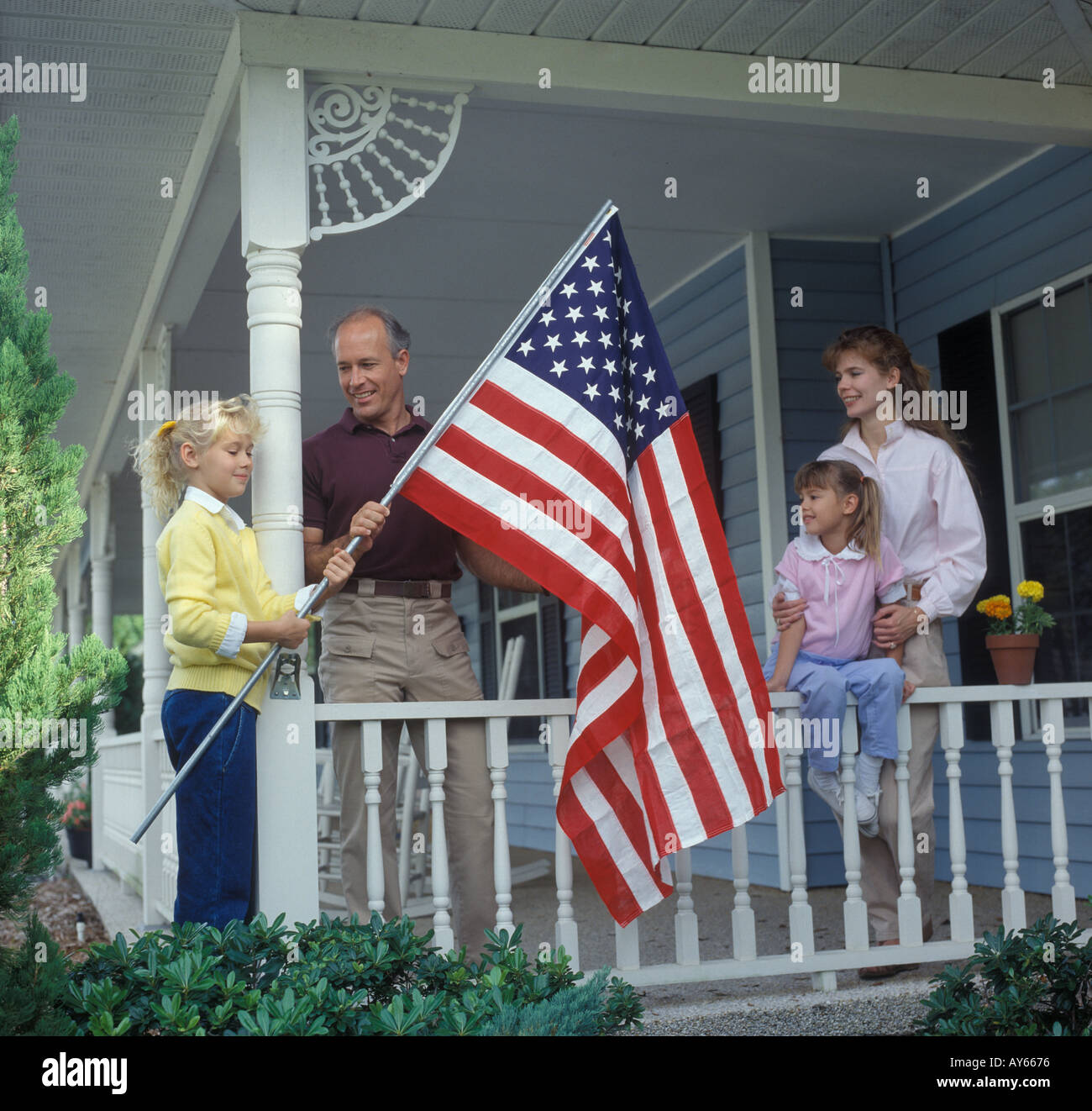 Familie von vier amerikanischen Flagge auf Veranda aufstellen Stockfoto