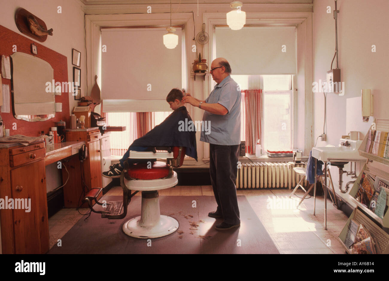 Joe der Friseur verleiht einen Haarschnitt einem kleiner Junge in Exeter New Hampshire USA Stockfoto
