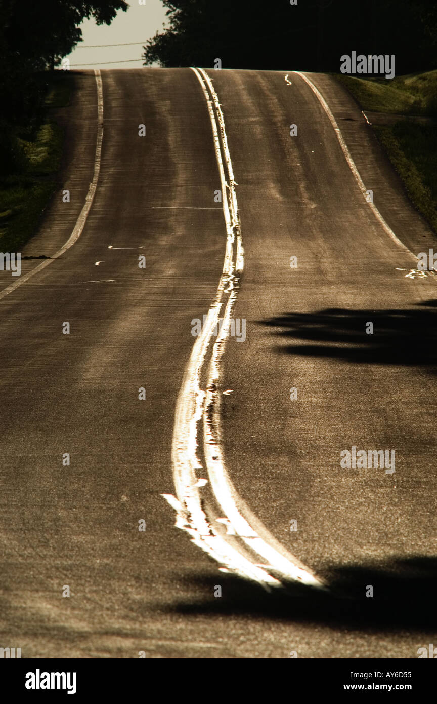 Morgensonne spiegelt sich in doppelte gelbe Linie im Straßenverkehr USA Stockfoto