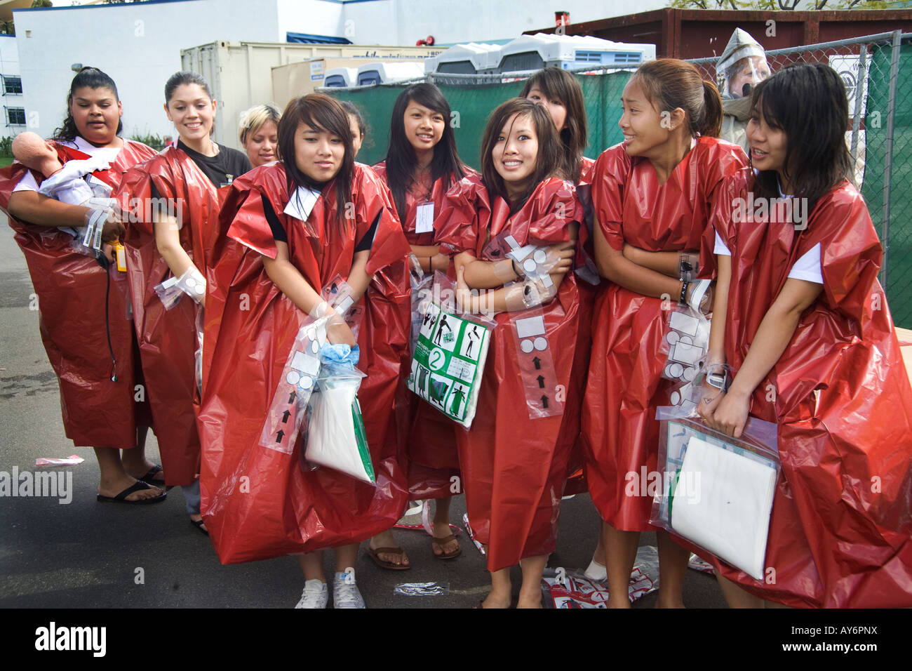 Eine multiethnische Gruppe von Freiwilligen Opfer im Notfall Einwegbekleidung Zittern nach wird mit einem Wasserstrahl dekontaminiert Stockfoto