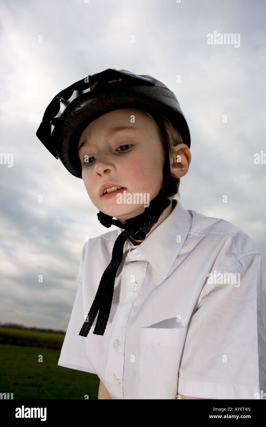 kleiner Junge sucht ängstlich mit Fahrradhelm auf Stockfoto