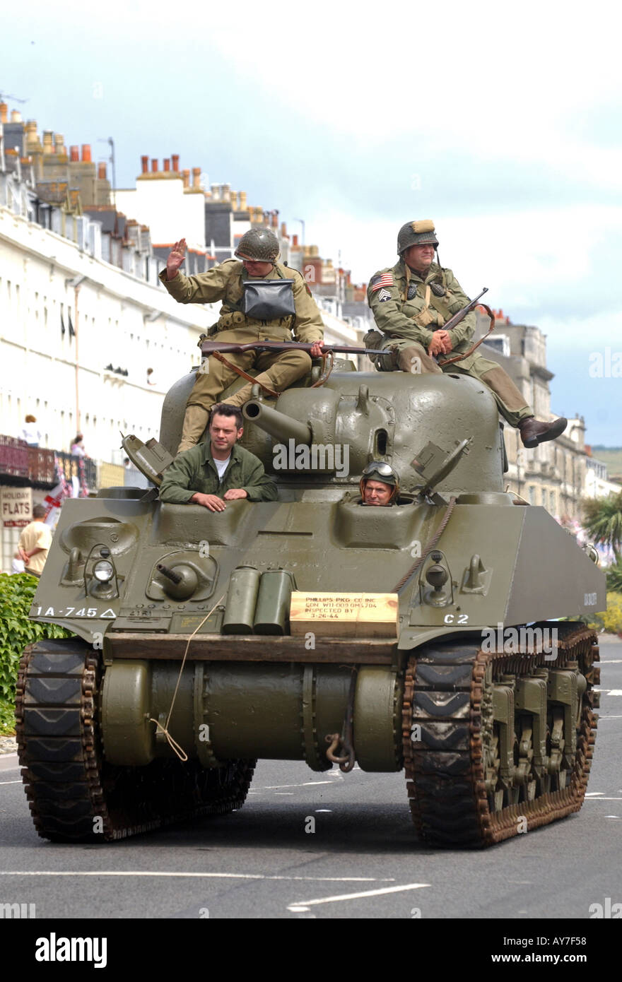 Ein Sherman-Panzer des 2. Weltkrieges mit Menschen in Zeit während einer Parade uniform gekleidet Stockfoto