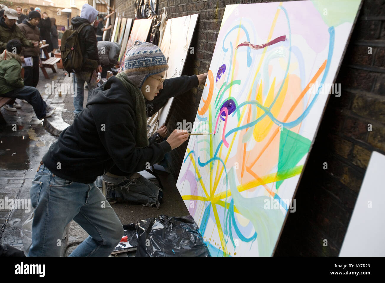 Japanischer junge Künstler malen bei Eröffnung Kunst zeigen Brick Lane London uk Stockfoto