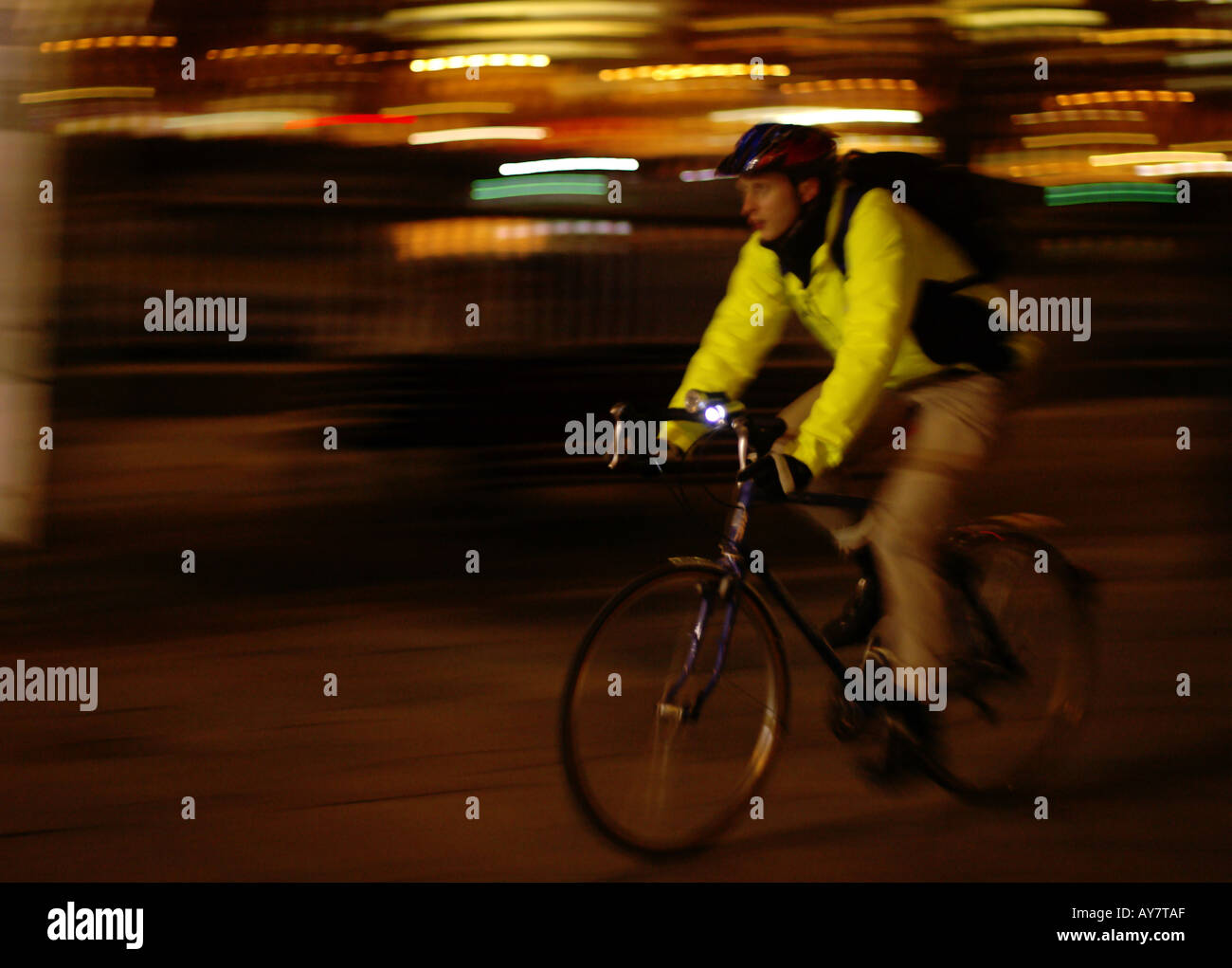 Mann Reiten Fahrrad in gelb oben in der Nacht in Stadt von London South Bank Stockfoto