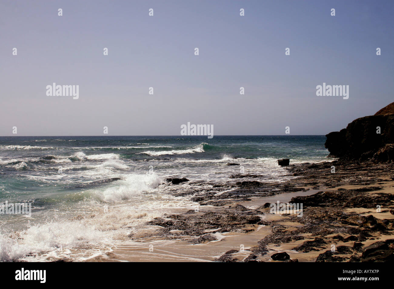 Ein MARINE MIT WEISSEN SURF brechen an der felsigen Küste. Stockfoto