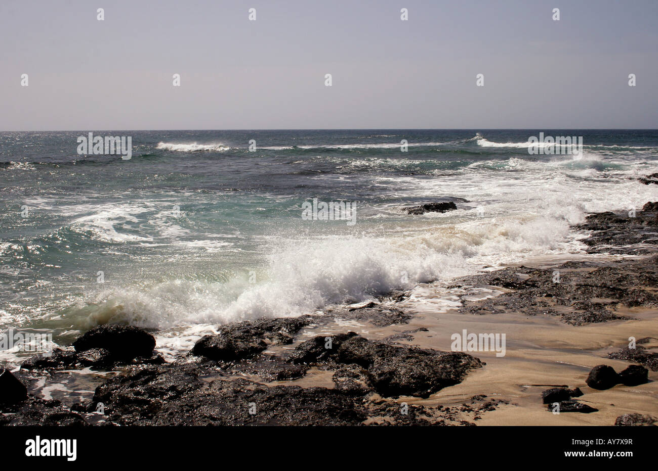 Ein MARINE MIT WEISSEN SURF brechen an der felsigen Küste. Stockfoto