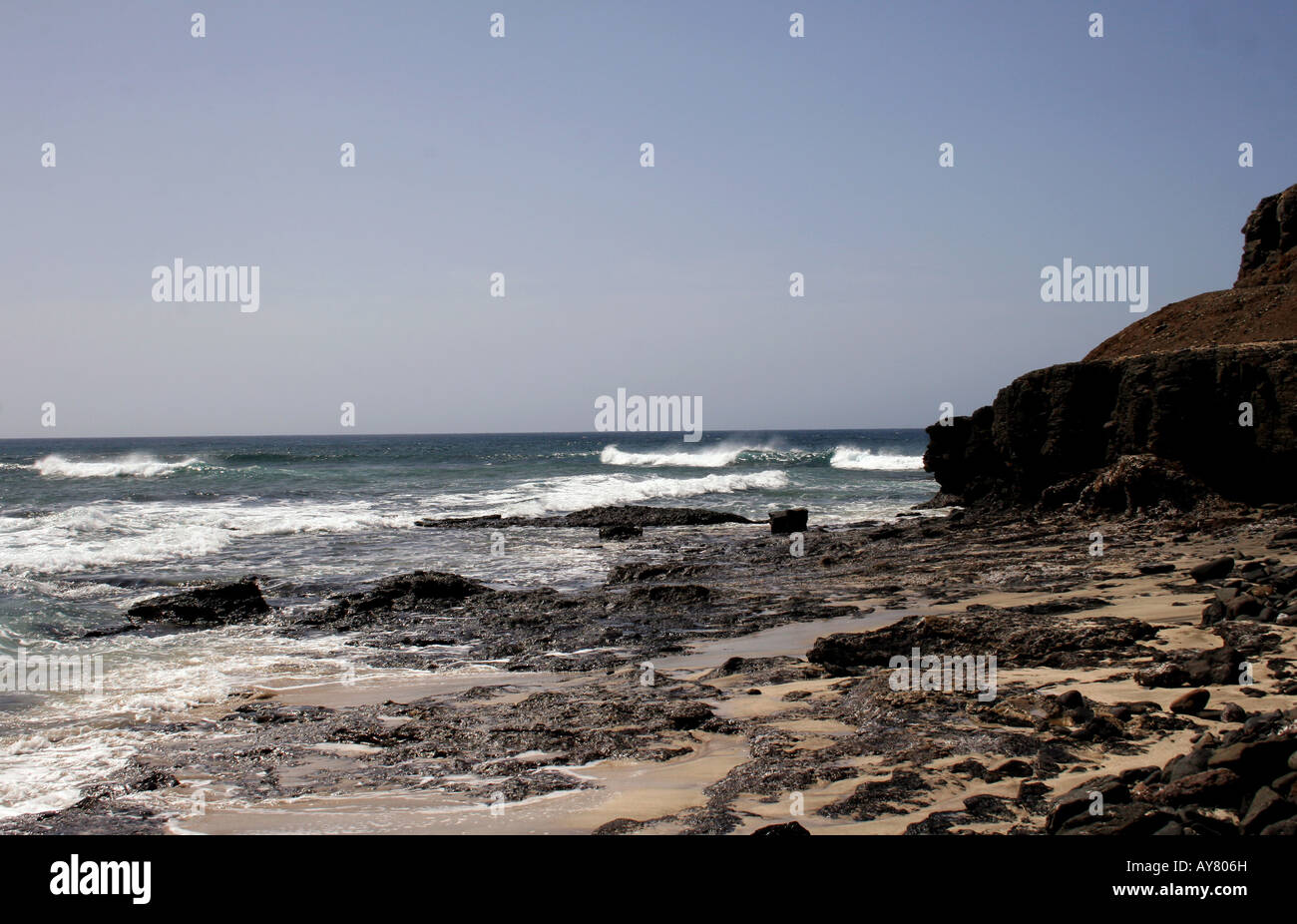 Ein MARINE MIT WEISSEN SURF brechen an der felsigen Küste. Stockfoto